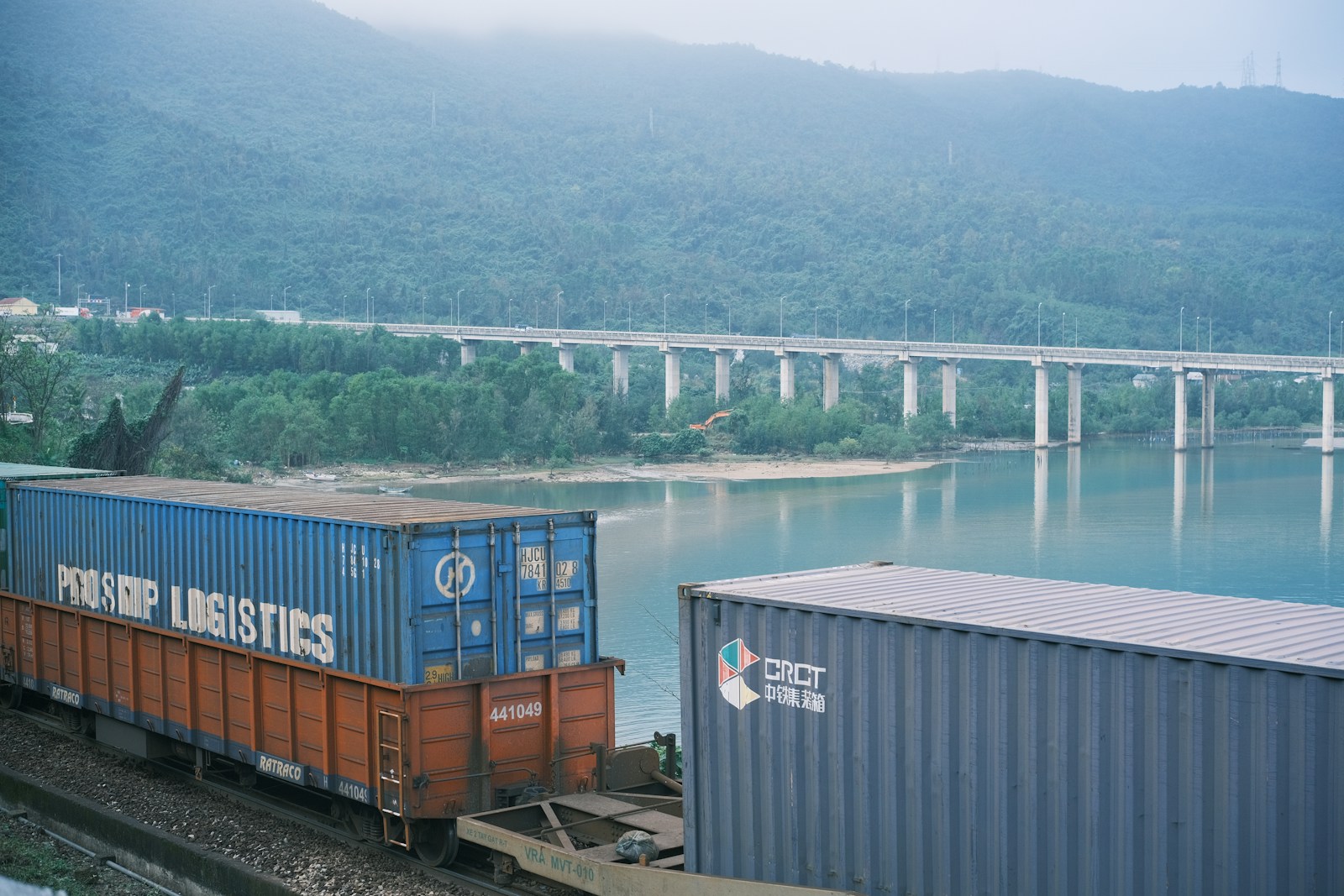 A train traveling down tracks next to a body of water
